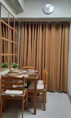 a dining room with a table and chairs and a clock at JML's Condo at Shore 3 Tower 2 in Manila