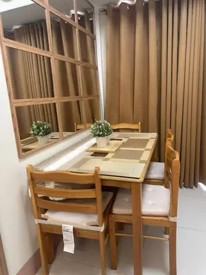 a wooden table and chairs with plants on it at JML's Condo at Shore 3 Tower 2 in Manila