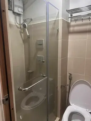 a bathroom with a toilet and a glass shower stall at JML's Condo at Shore 3 Tower 2 in Manila
