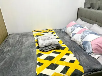 a bed with a blanket and pillows on it at Mall of Asia View Condo Living - Shore in Manila