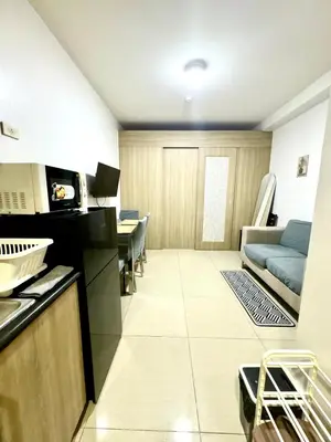 a kitchen and a living room with a couch at Mall of Asia View Condo Living - Shore in Manila
