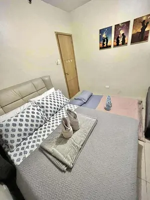 a bedroom with a bed with two pairs of shoes on it at Staycation Near Mall of Asia in Manila