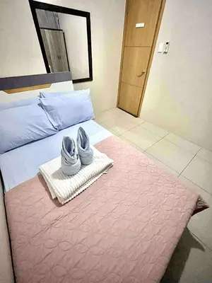a pair of shoes sitting on a bed with a rug at Staycation Near Mall of Asia in Manila