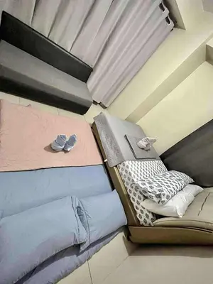 a bed with two pairs of shoes sitting on it at Staycation Near Mall of Asia in Manila