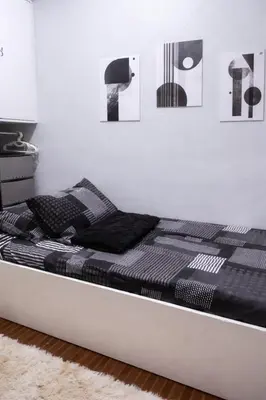 a bed in a room with black and white pictures on the wall at Islana Stay Rm B for 1pax only in General Trias