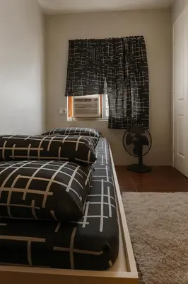 a bedroom with two beds with pillows and a window at Islana Stay Rm B for 1pax only in General Trias