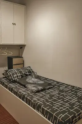 a bedroom with a bed and a white cabinet at Islana Stay Rm B for 1pax only in General Trias