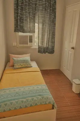 a small bedroom with a bed and a window at Islana Stay Rm B for 1pax only in General Trias