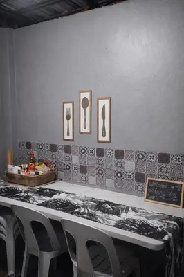 a table with chairs in front of a wall with pictures at Islana Stay Rm B for 1pax only in General Trias