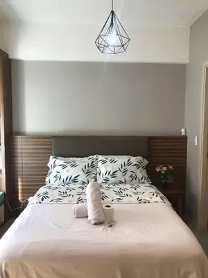 a bedroom with a large bed with white sheets at Newport Condo near T3 - H in Manila