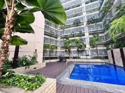 a building with a swimming pool in front of a building at Newport Condo near T3 - H in Manila