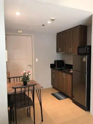 a kitchen with a table and a black refrigerator at Newport Condo near T3 - H in Manila