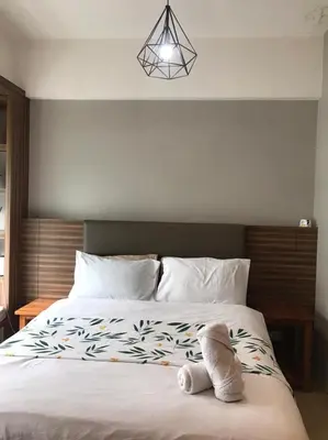 a bed with a stuffed animal sitting on top of it at Newport Condo near T3 - H in Manila