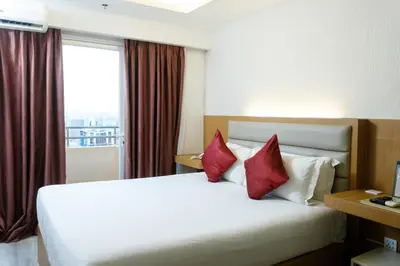 a hotel room with a large bed with red pillows at LivStudios Manila Bay in Manila