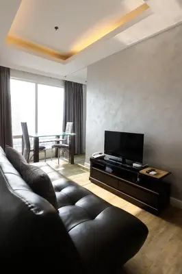 a living room with a couch and a television at LivStudios Manila Bay in Manila