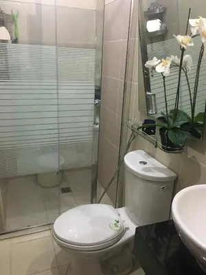 a bathroom with a toilet and a shower and a sink at 1BR Pioneer Woodland Condominium connected to BONI Metro Rail Station,Boni Mandaluyong Metro Manila in Manila