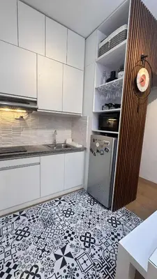 a kitchen with white cabinets and a black and white tile floor at 1BR Pioneer Woodland Condominium connected to BONI Metro Rail Station,Boni Mandaluyong Metro Manila in Manila