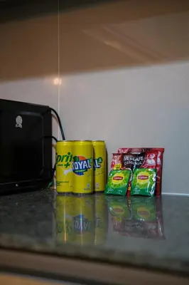 two cans of potato chips and a laptop on a counter at Solstice at BGC- Modern & Stylish 1BR in Uptown BGC in Manila