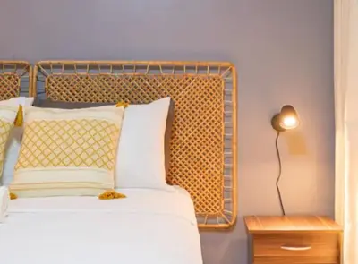 a bed with a metal headboard and a table with a lamp at Solstice at BGC- Modern & Stylish 1BR in Uptown BGC in Manila