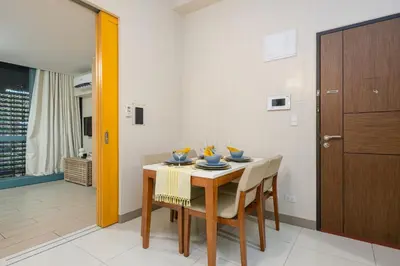 a dining room with a table and chairs at Solstice at BGC- Modern & Stylish 1BR in Uptown BGC in Manila