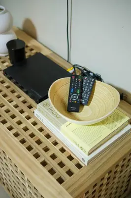 a remote control sitting on top of a wooden table at Solstice at BGC- Modern & Stylish 1BR in Uptown BGC in Manila