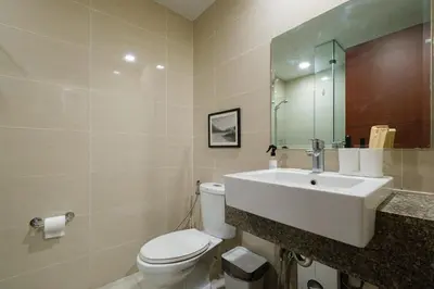 a bathroom with a white toilet and a sink at Solstice at BGC- Modern & Stylish 1BR in Uptown BGC in Manila