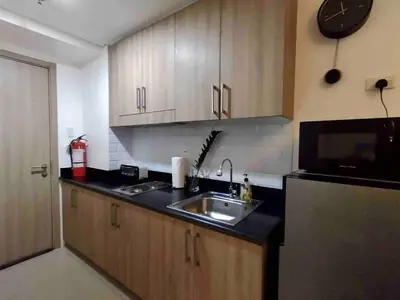 a kitchen with a sink and a clock on the wall at Erick 1 bedroom Shore Residence 1 in Manila