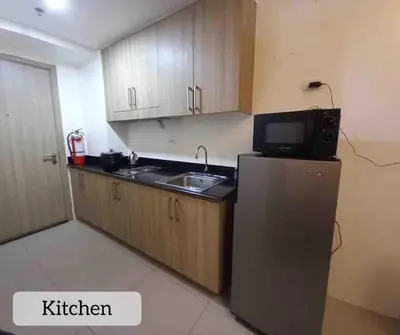 a kitchen with a sink and a refrigerator at Erick 1 bedroom Shore Residence 1 in Manila