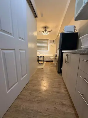 a hallway leading to a kitchen with a door at Urban Oasis Cozy Studio at Berkeley Suites South Forbes Nuvali in Silang