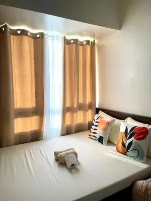 a bed with a teddy bear sitting on top of it at Minimalist Cozy condo in Makati,Netflix,Sauna,Pool in Manila