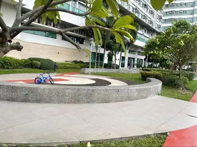a blue bike parked in a park in front of a building at Minimalist Cozy condo in Makati,Netflix,Sauna,Pool in Manila