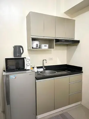 a small kitchen with a sink and a microwave at Minimalist Cozy condo in Makati,Netflix,Sauna,Pool in Manila