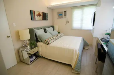a bedroom with a large bed in a room at Cozy Condo in Manila