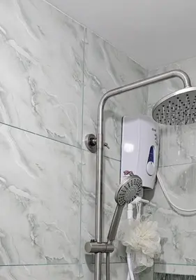 a shower with a hair dryer on a wall at 1 Bedroom Townhouse with Airconditon ,Water heater and free wifi,fully furnished in San Roque