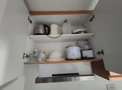 a kitchen shelf with dishes and other items on it at Buong tuluyan sa Pasay in Manila
