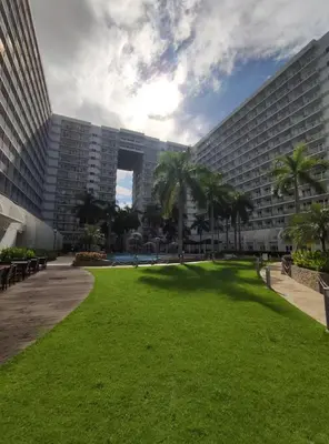a large building with a green lawn in front of it at Buong tuluyan sa Pasay in Manila