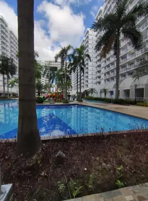 a large swimming pool in front of a large building at Buong tuluyan sa Pasay in Manila