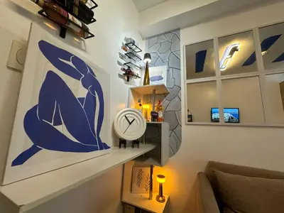 a living room with a blue and white painting on the wall at Shore Residence Casa Margarita in Manila