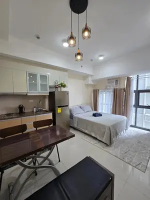 a large bedroom with a bed and a kitchen at Condo unit in Taguig in Manila