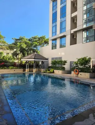 a swimming pool in front of a building with a gazebo at Condo unit in Taguig in Manila