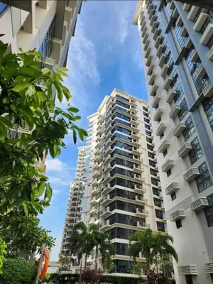 a tall apartment building with palm trees in the foreground at Condo unit in Taguig in Manila