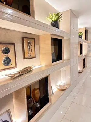 a living room with a wall of glass shelves at Shell Residences MOA Paul's Place in Manila