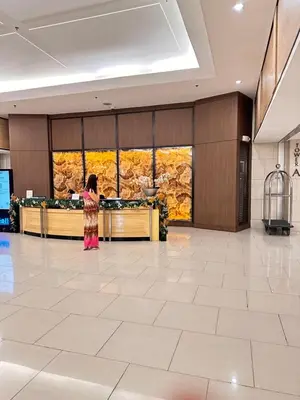 a woman standing in the lobby of a hotel at Shell Residences MOA Paul's Place in Manila