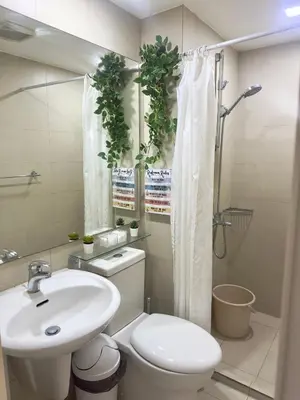 a bathroom with a toilet and a sink and a shower at Cityscape Staycation by H&B in Manila