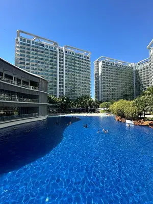 a large swimming pool in front of tall buildings at Cityscape Staycation by H&B in Manila
