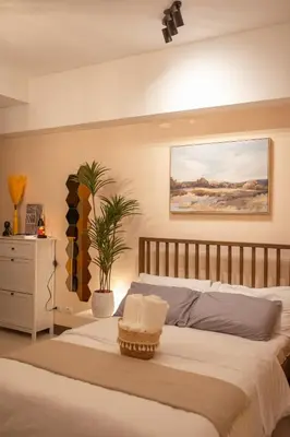a bedroom with a large bed and a painting on the wall at Stingga McKinley Aesthetic Studio in Venice in Manila