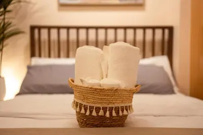 a basket of towels sitting on top of a bed at Stingga McKinley Aesthetic Studio in Venice in Manila