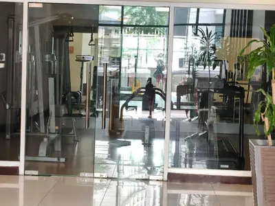 an empty lobby with glass doors and plants at Asthrea Condotels in front of NAIA Terminal 3 Airport in Manila