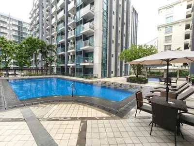 a swimming pool in front of a tall building at Asthrea Condotels in front of NAIA Terminal 3 Airport in Manila