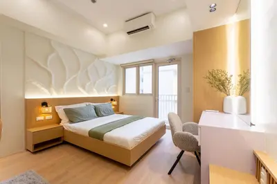 a bedroom with a bed and a desk and a window at Luxury 1 BR City View in Park Mckinley West Fast Wi-Fi Washer Dryer in Manila